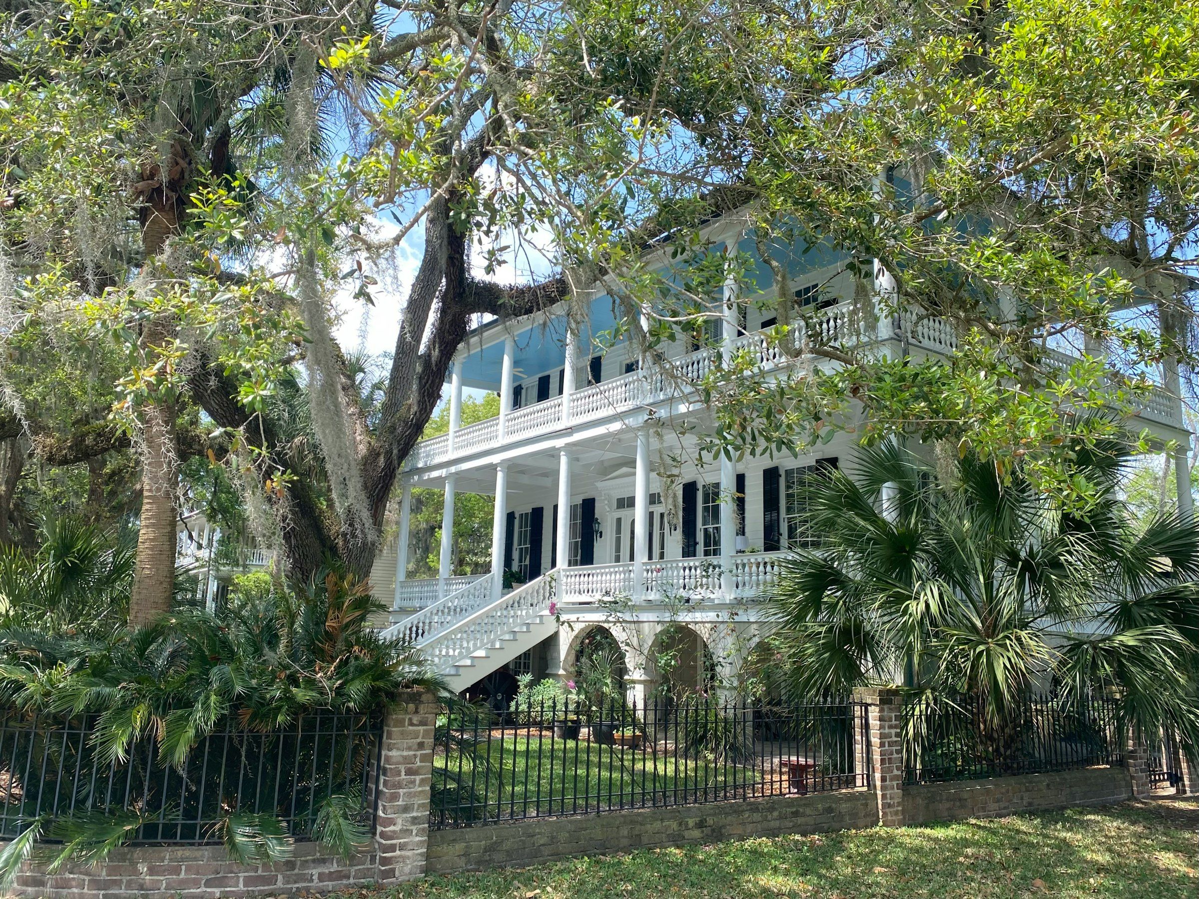 A historic two-story home with double wraparound porches under live oaks in Beaufort, SC