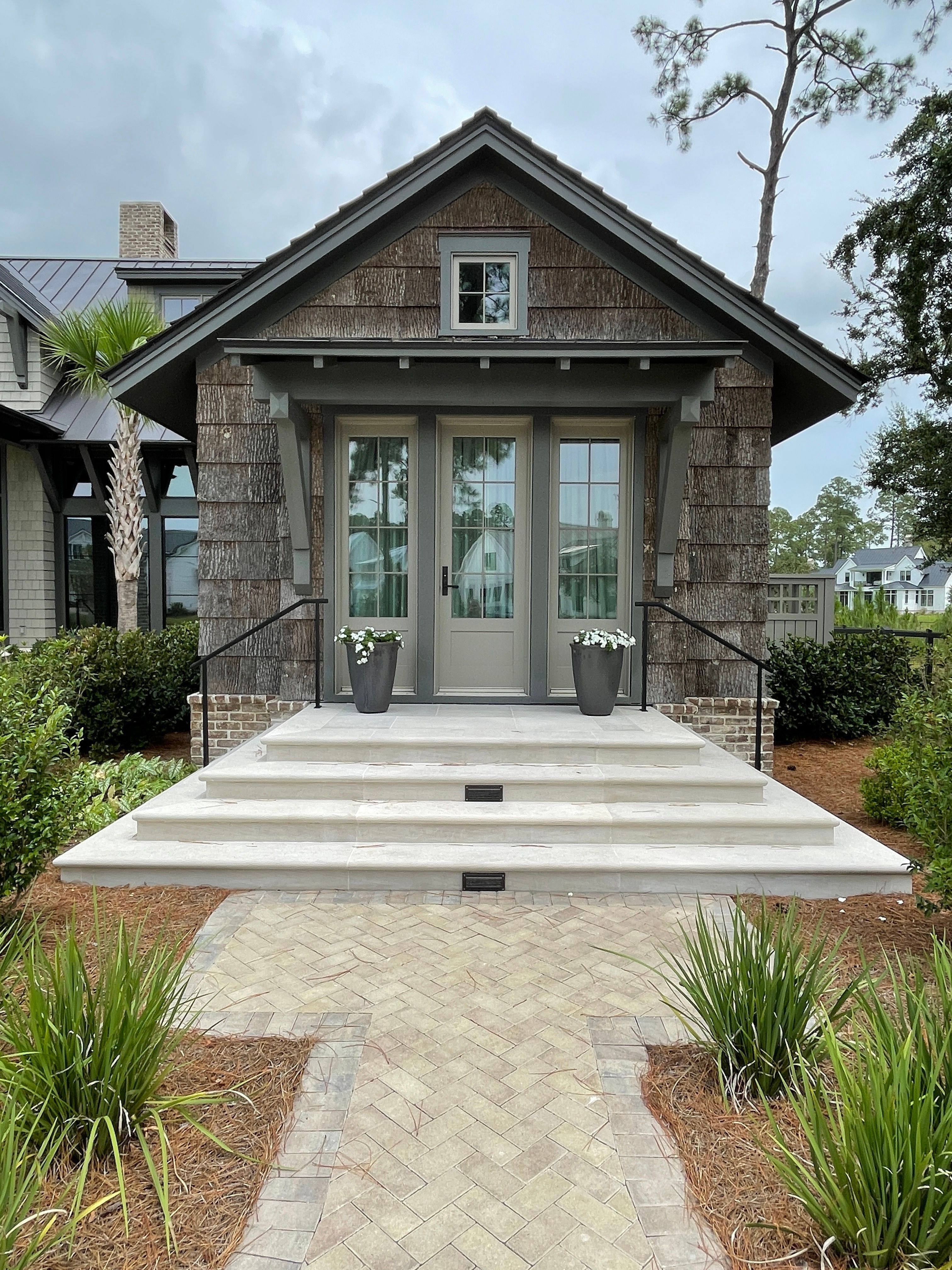 A craftsman-style home entrance in Bluffton, SC with painted cedar-shake siding and trim