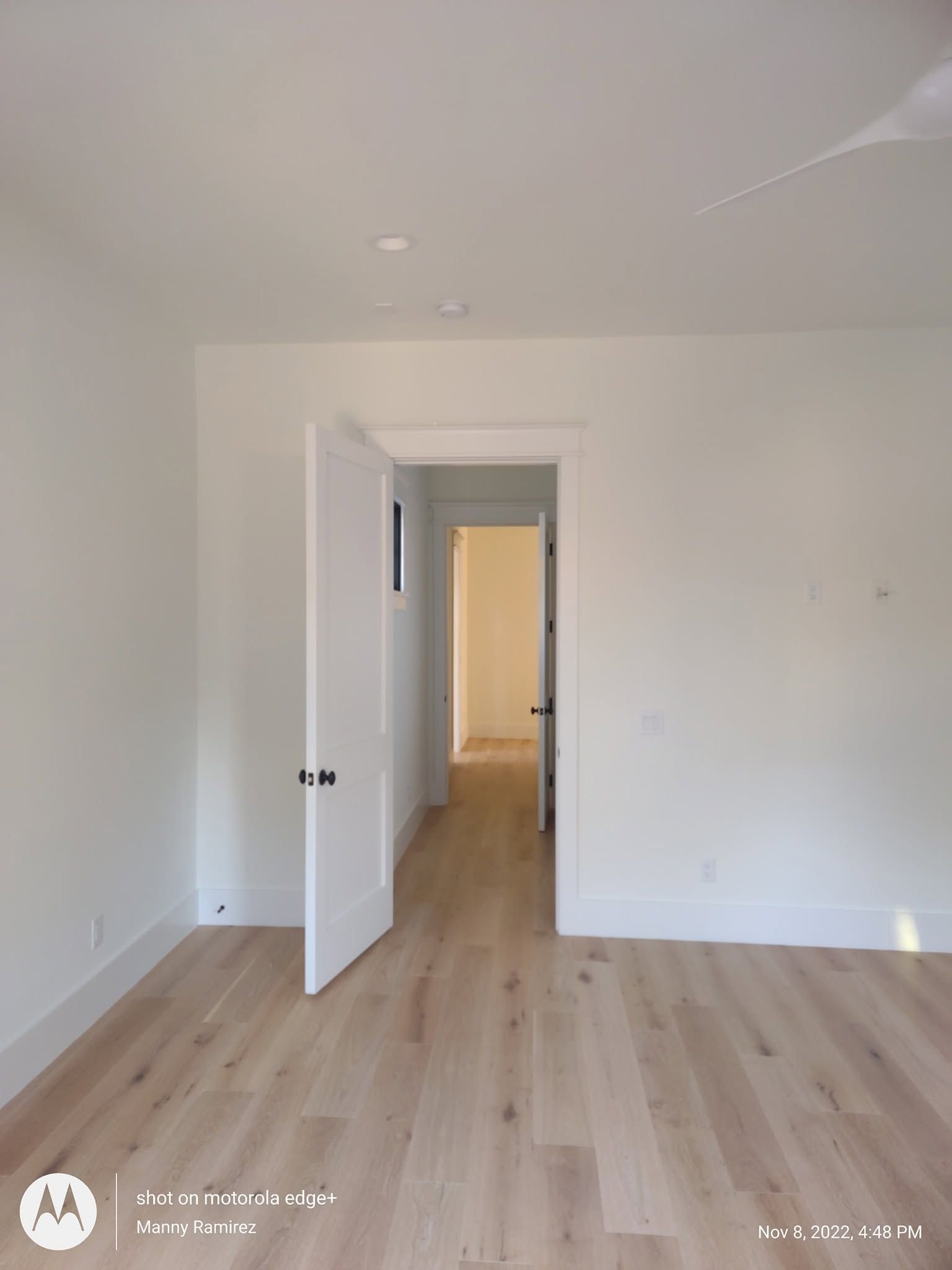 Freshly painted white room with open doorway revealing a corridor