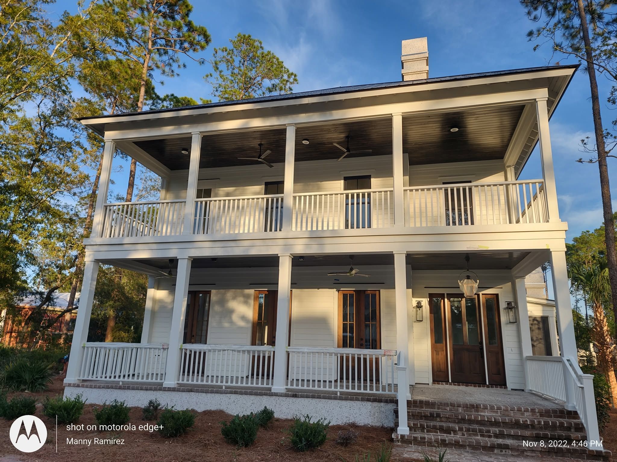 Painted Lowcountry home with double wraparound porches and stained French doors
