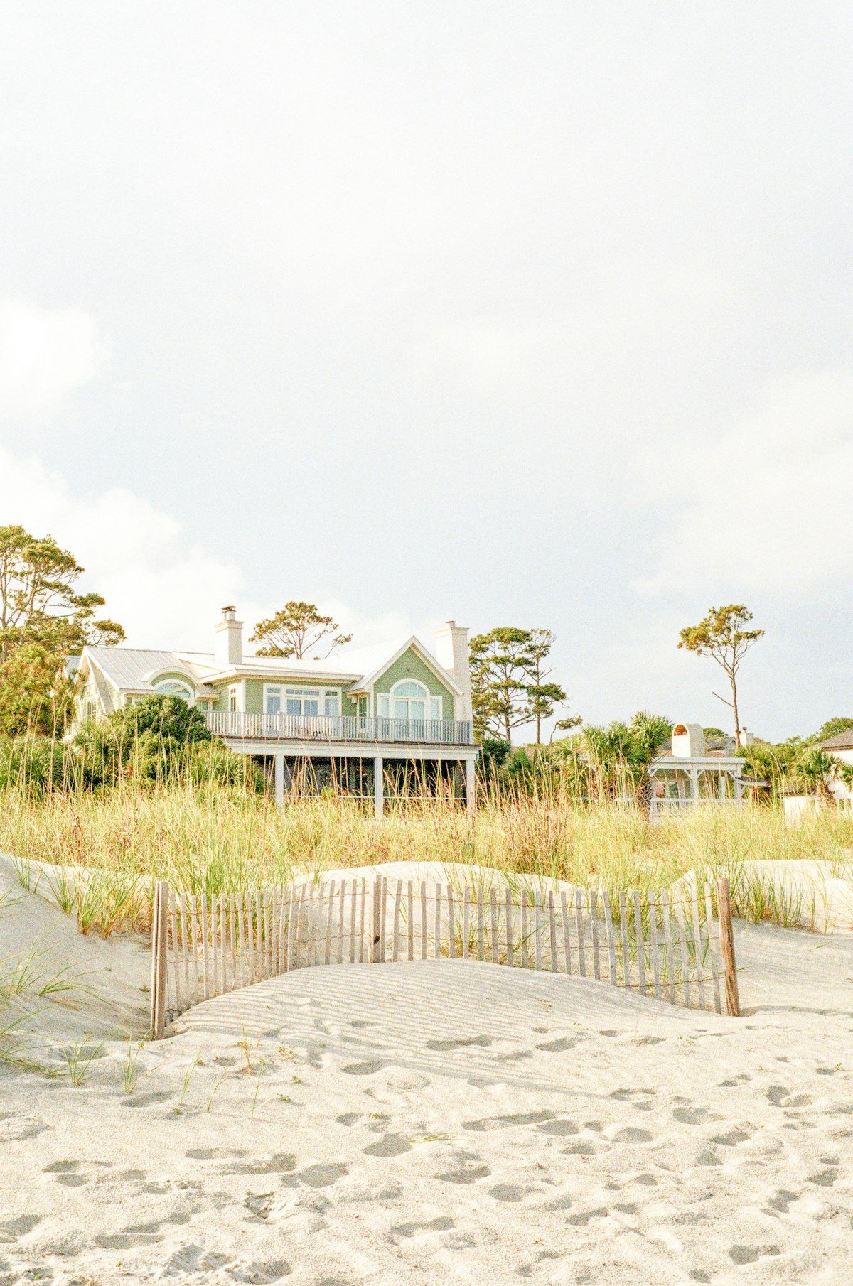 A Hilton Head Island beach house behind dune grass and a sand fence